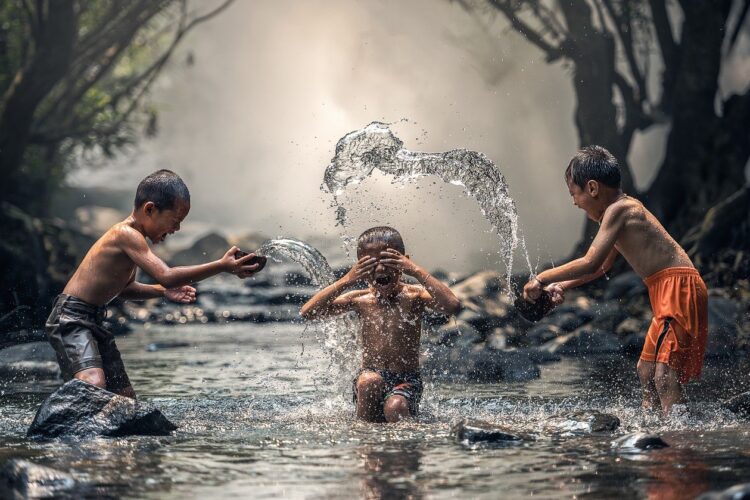 imagem de três crianças a brincar na água